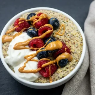 Keto Oatmeal Breakfast Bowl topped with creamy Greek yogurt, fresh mixed berries, and a drizzle of almond butter.