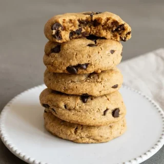 Baked keto peanut butter chocolate chip cookies with a golden surface and melted sugar-free chocolate chips.