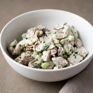 Creamy keto chicken salad with juicy chicken thighs, crisp celery, and toasted pecans in a serving bowl.