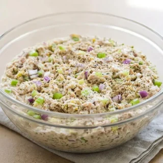 A bowl of creamy keto tuna salad recipe mixed with crisp celery, red onion, and dill relish.
