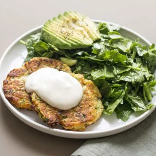 Crispy keto zucchini fritters pan-fried to a rich golden brown with tender savory centers.