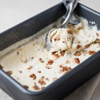 Scoops of velvety keto butter pecan ice cream with toasted buttery pecans and glossy custard texture.
