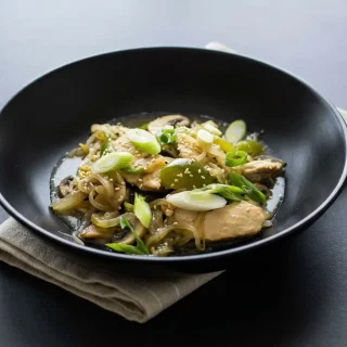 Sizzling keto chicken stir fry in a hot wok with tender chicken strips, crisp celery, and sesame seeds.