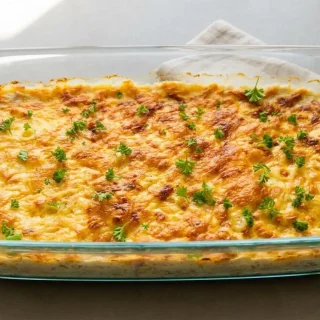 Keto tuna noodle casserole with tender pasta ribbons and a bubbly golden Gouda cheese crust in a baking dish.