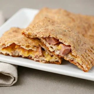 Golden baked keto hot pockets with a crisp almond flour crust and melted ham and cheddar filling.