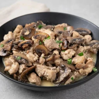 Keto chicken and mushrooms in a rich, velvety garlic Dijon cream sauce with browned quartered mushrooms.