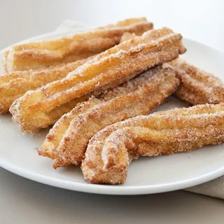 Golden crisp keto churros coated in sparkling cinnamon sweetener with defined fluted ridges.