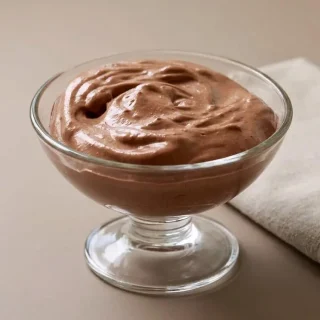 Keto cottage cheese chocolate mousse served chilled in a glass cup with a glossy, velvety finish.