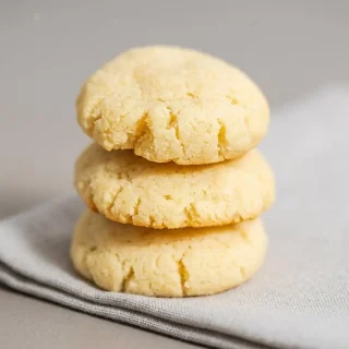 Keto cream cheese cookies recipe showing tender, pillowy centers with light golden baked edges on a cooling rack.