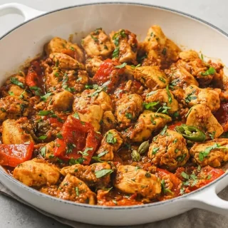 A rich keto curry recipe with tender chicken cubes, crisp red peppers, and a glossy spiced yogurt gravy.