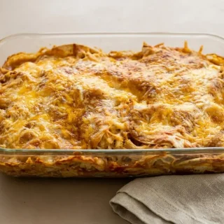 Baked keto enchilada casserole with bubbling red sauce and a golden browned melted cheese crust.