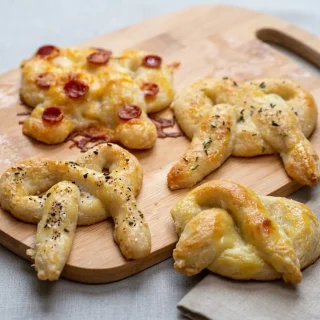 Keto soft pretzel recipe featuring a golden glossy crust sprinkled with coarse salt flakes.