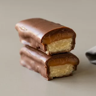 Chilled keto twix bars with crisp shortbread, golden caramel, and a glossy dark chocolate coating.