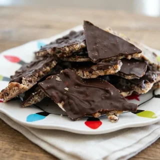 Chilled shards of keto christmas crack with golden toasted pecan toffee and a firm dark chocolate topping