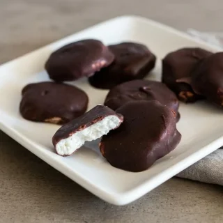 Chilled keto peppermint patties with creamy white mint centers coated in crisp dark chocolate.