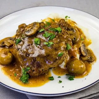 Keto salisbury steak seared tender beef patties covered in glossy mushroom pan gravy